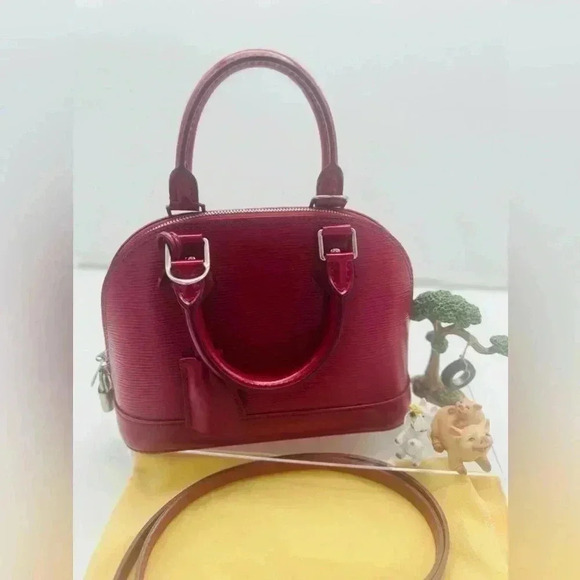 Louis Vuitton's Epi Alma BB in striking fuchsia, featuring silver-tone hardware - Picture 1 of 6